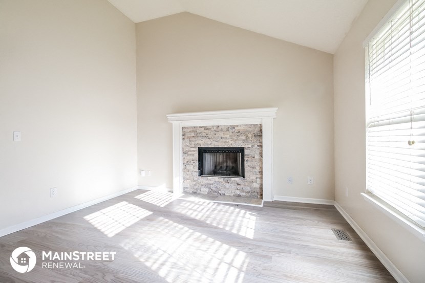 a living room with a fireplace and wood floors