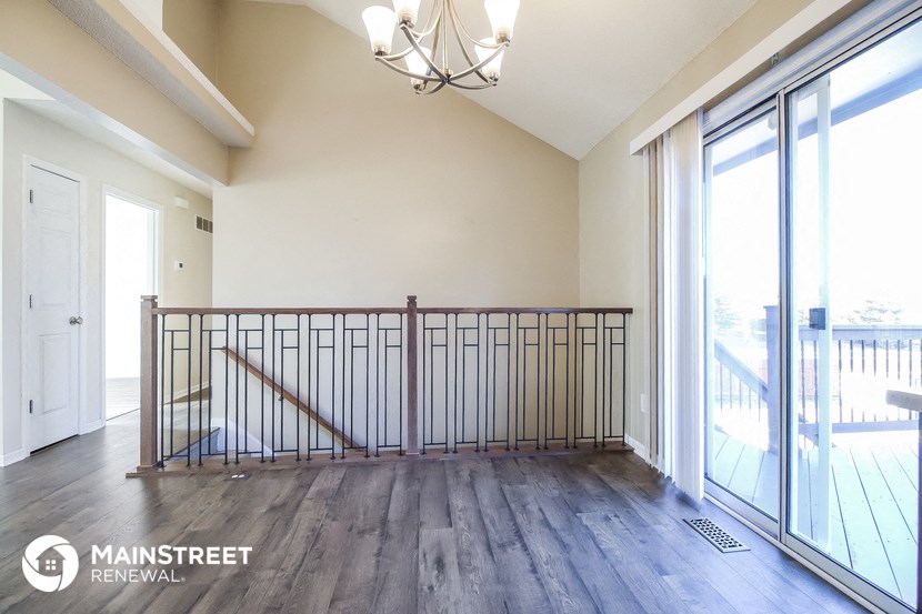 an empty living room with a balcony and a glass door