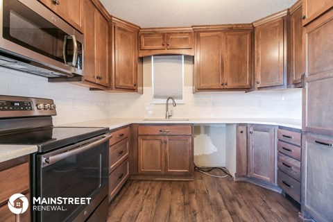 a kitchen with wooden cabinets and a stove and a microwave
