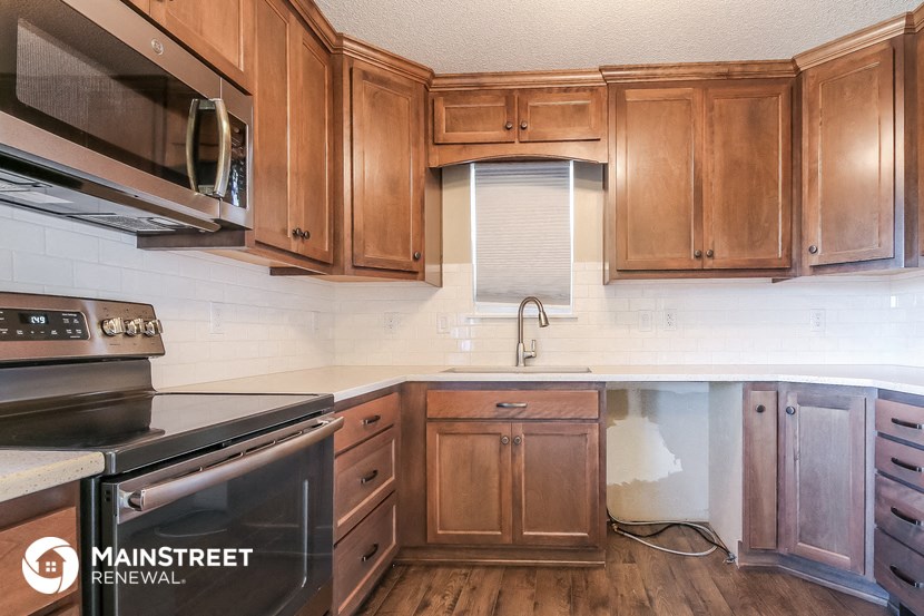 a kitchen with wooden cabinets and a stove and a microwave