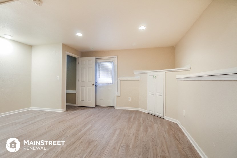 an empty living room with white walls and wood floors
