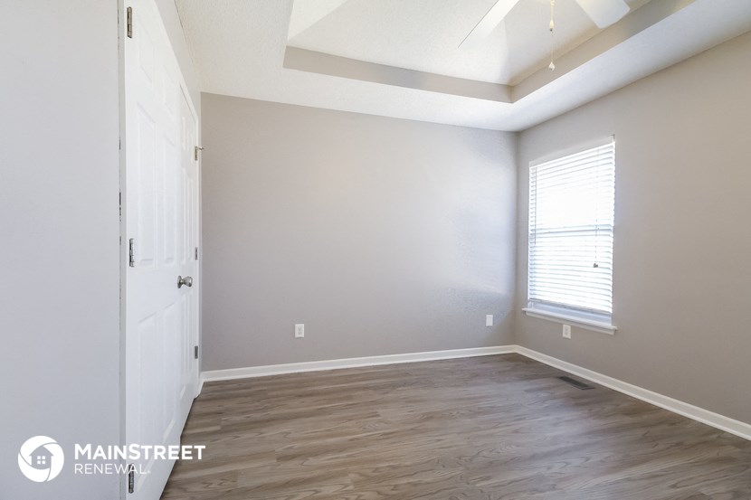 the living room of a new home with wood flooring and a window