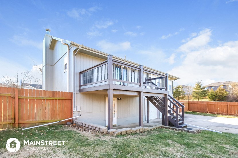 a small house with a deck on top of a driveway