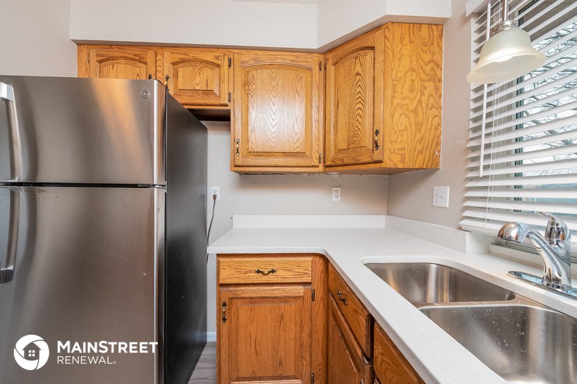 a kitchen with wooden cabinets and a stainless steel refrigerator
