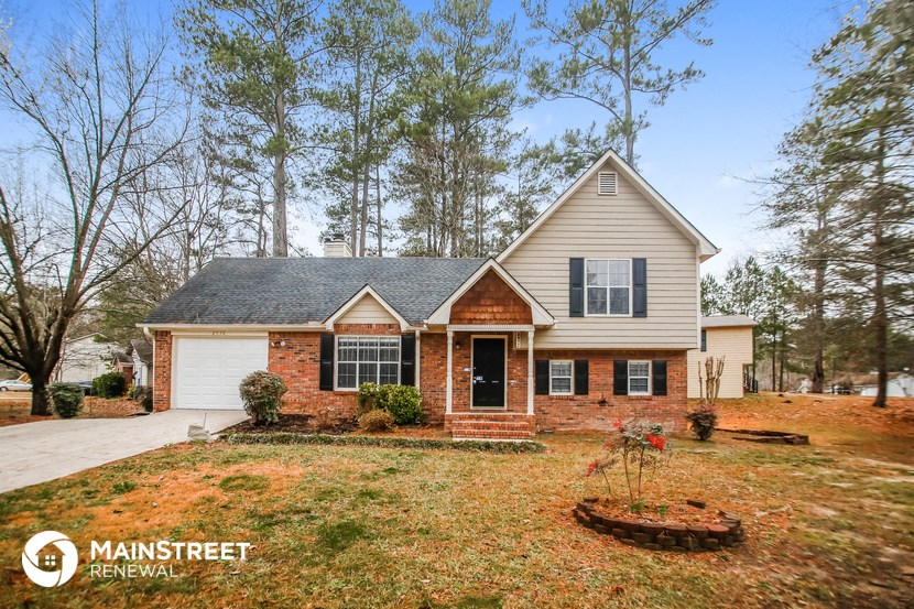 front view of a home with a lawn and trees