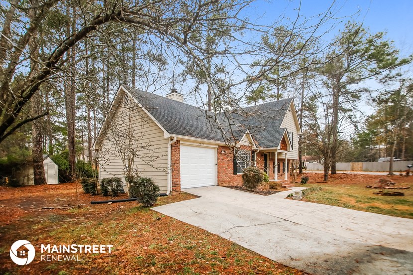 a small brick house with a garage and a driveway