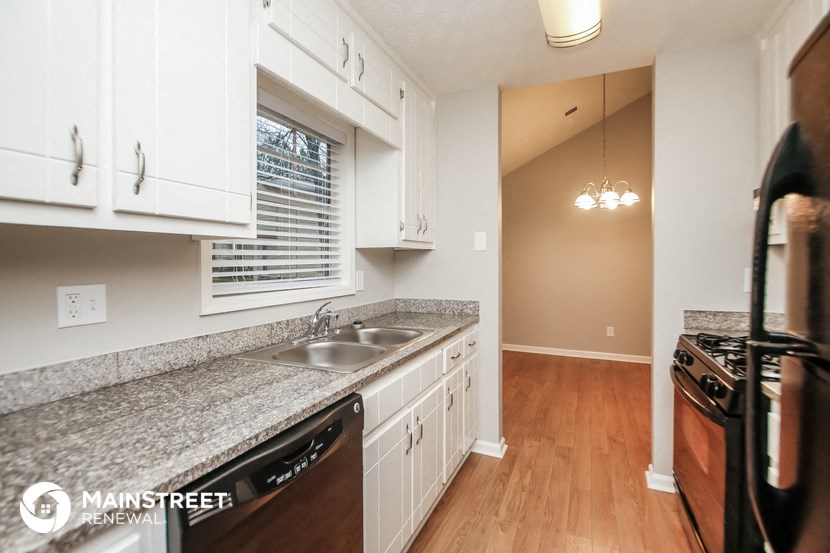 a kitchen with white cabinets and granite counter tops and a sink