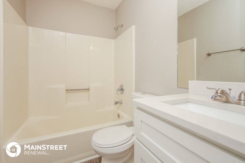 a bathroom with a toilet and a tub and a sink