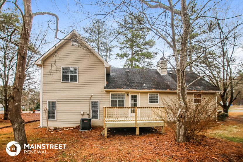 the front of the house has a deck and a porch