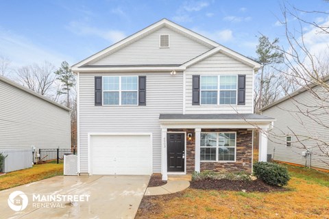 a white house with black shutters and a white garage door