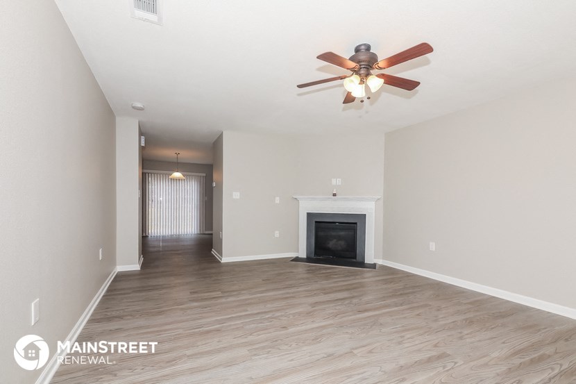 the living room with fireplace and ceiling fan