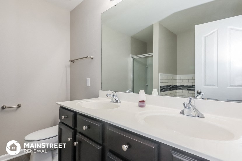 a bathroom with two sinks and a large mirror