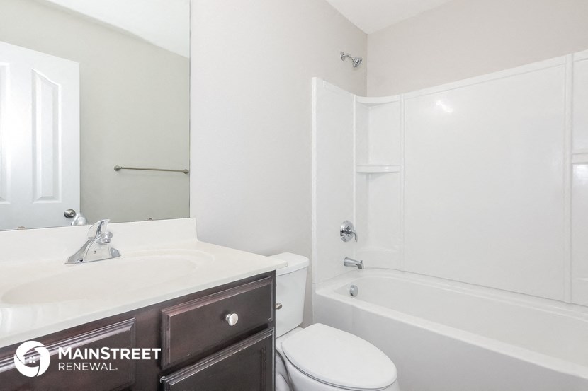 a white bathroom with a sink toilet and shower