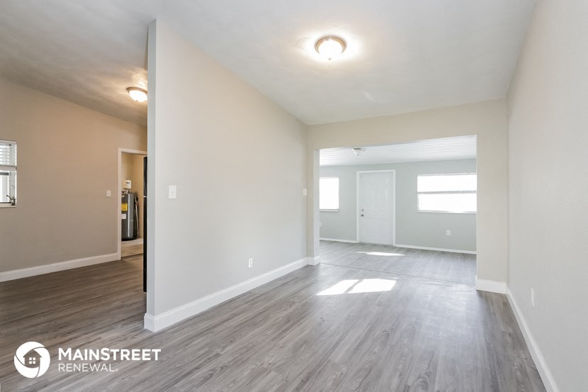 the living room and dining room of an apartment with wood flooring