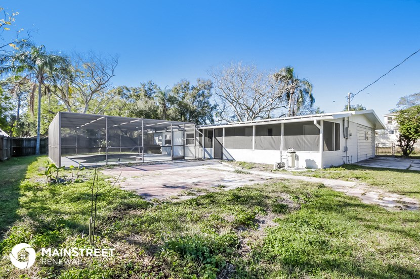 the exterior of a white house with glass doors and a yard