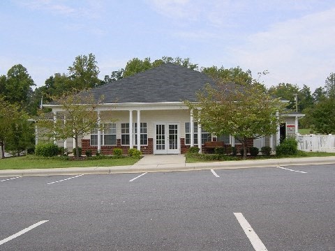 a white house with a porch and a parking lot