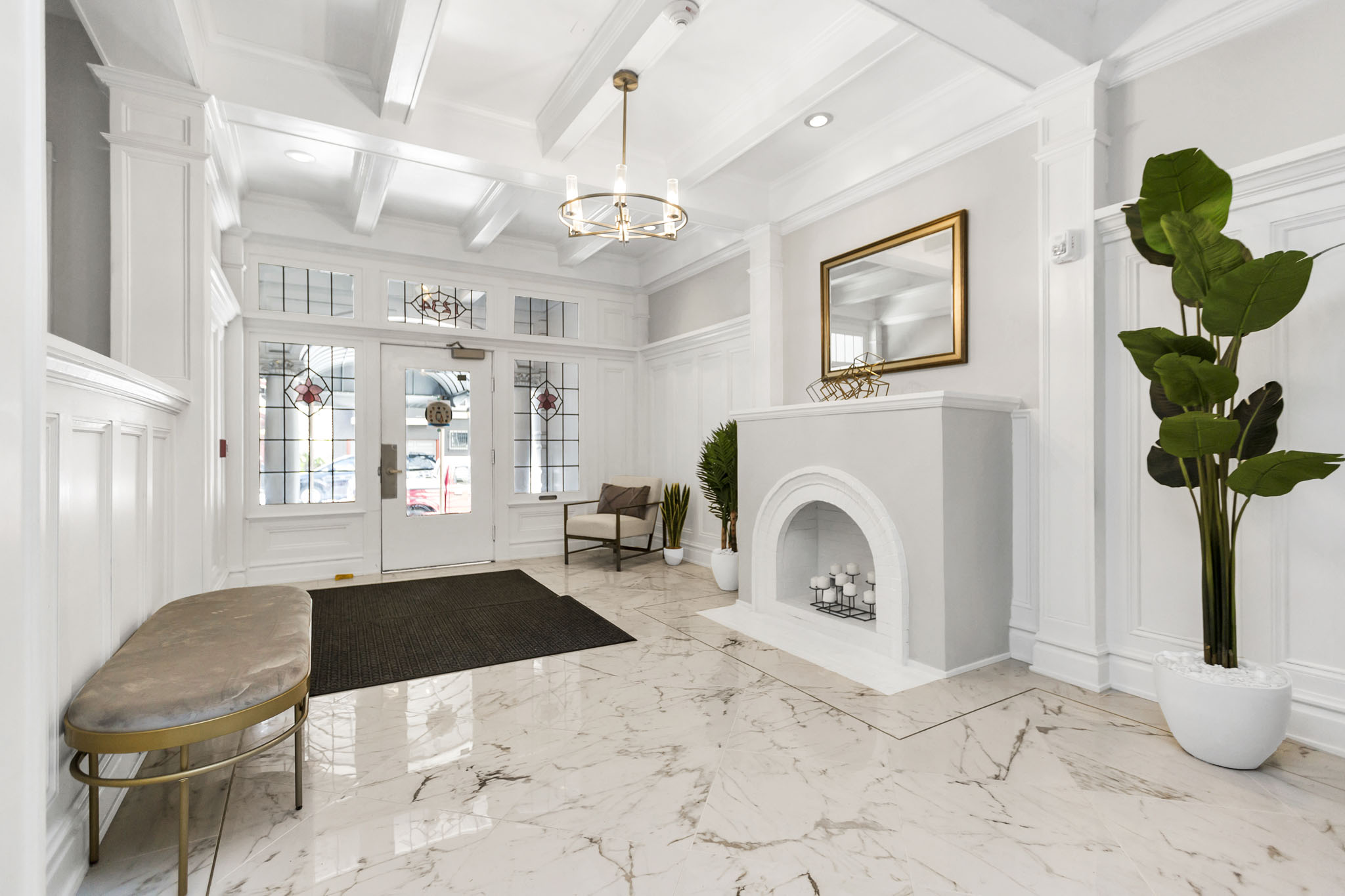 A white marble room with a fireplace and a mirror.