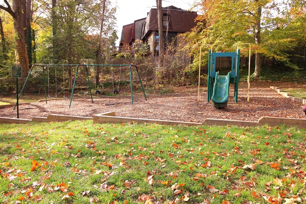 a playground with a swing set in a park