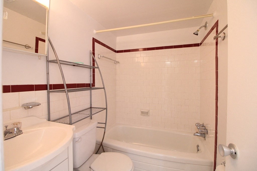 a white bathroom with a tub and a sink and a toilet