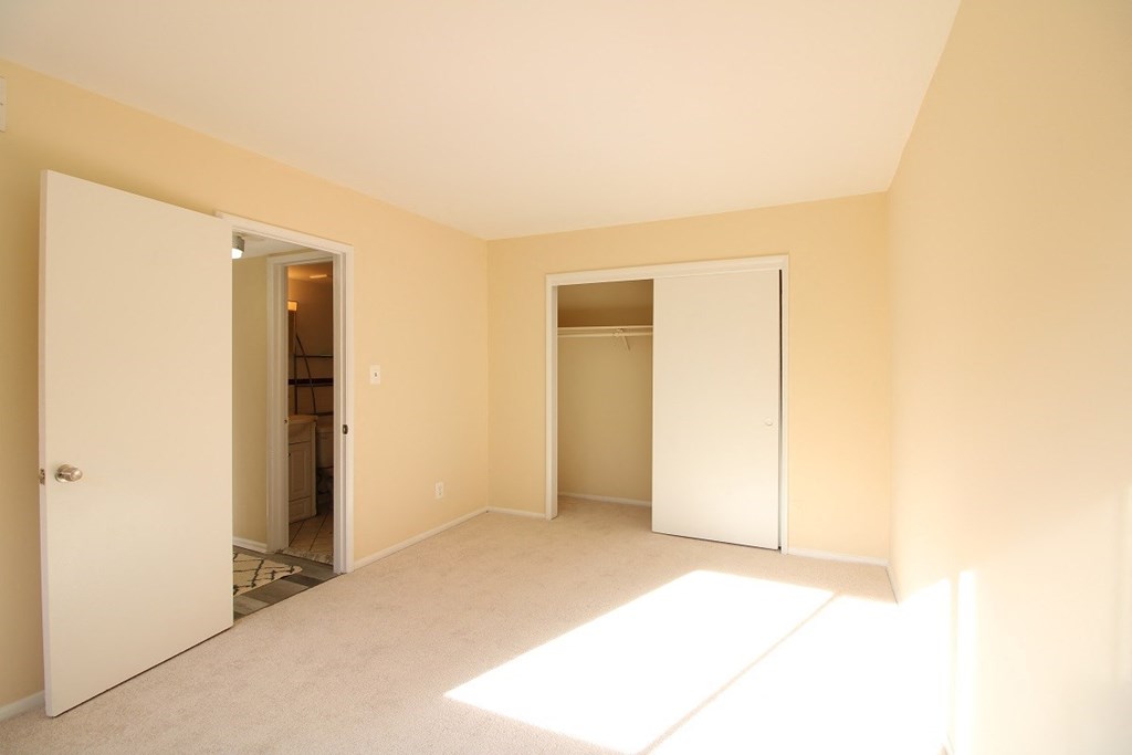 a bedroom with a closet and a door to a bathroom