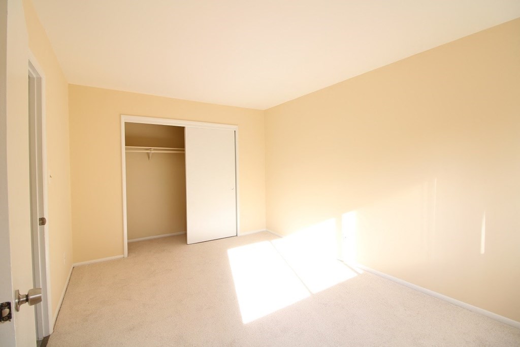 an empty living room with a door to a closet