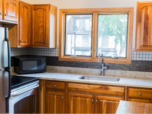 a kitchen with wooden cabinets and a sink and a window