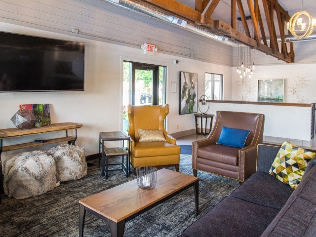 a living room with a couch and chairs and a television