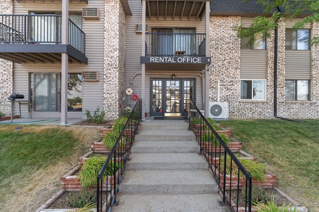 A stone building with a balcony and a sign that says Rental Office.