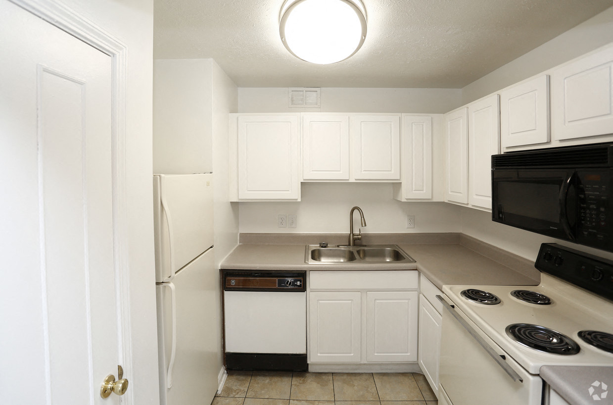 a kitchen with white cabinets and black appliances and a sink