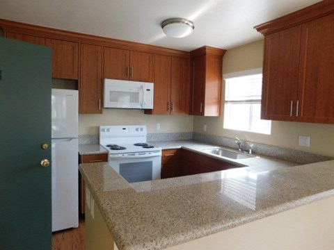 A kitchen with a white stove and a green door.