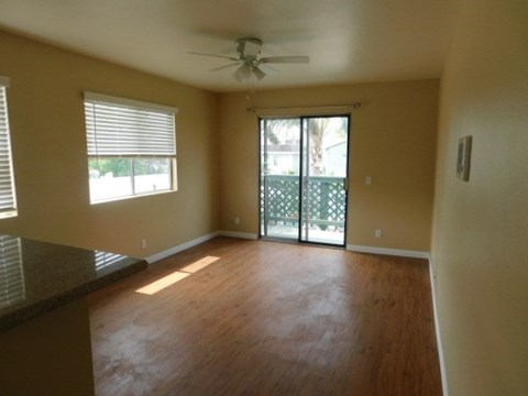 A room with a ceiling fan and sliding glass doors.