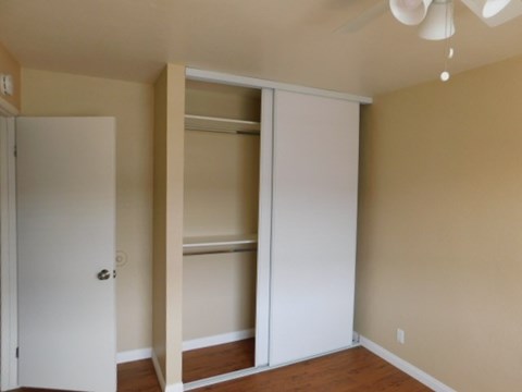 A room with a white door and a white closet with shelves.