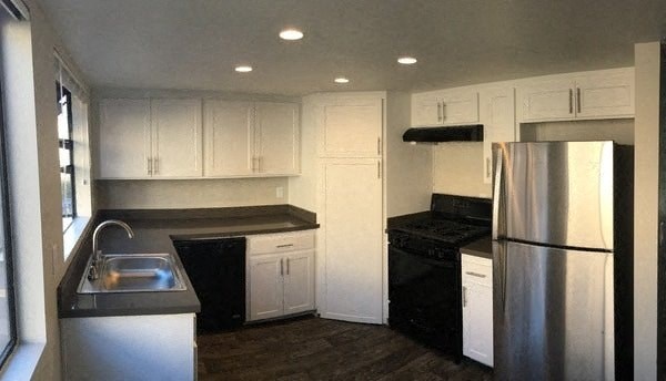 a kitchen with white cabinets and a stainless steel refrigerator