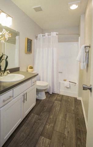 a bathroom with a toilet and a sink and a shower