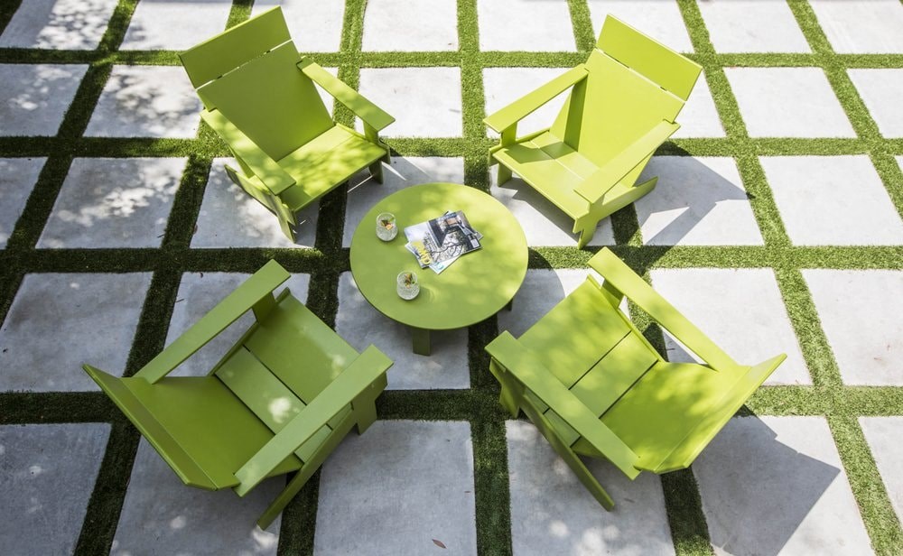 a group of green chairs and tables on a patio