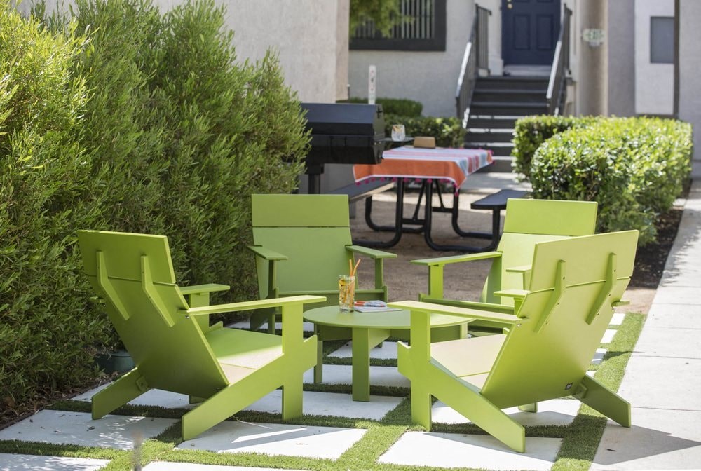 a group of green chairs and tables on a patio