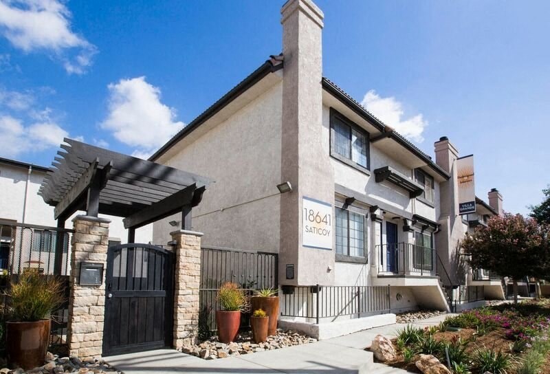the front of a building with a black gate