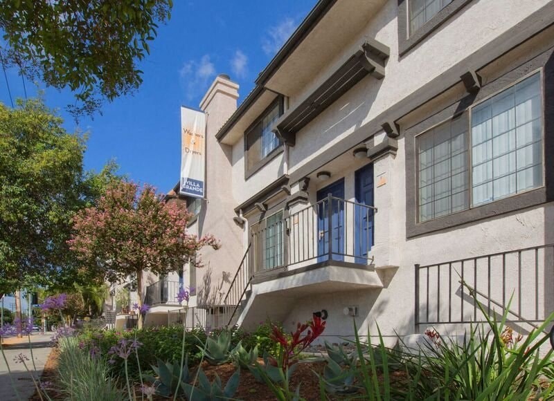 an apartment building with a balcony and plants