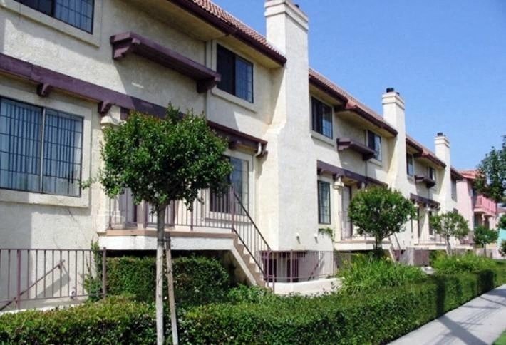 a row of houses with trees in front of them