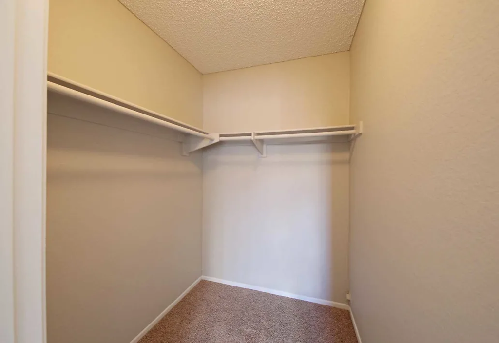 a closet in a room with a white wall and a curtain