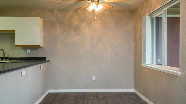 an empty room with a kitchen and a window