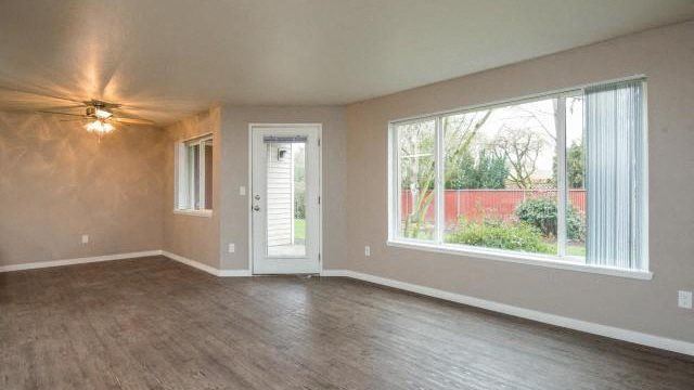 an empty living room with a large window and a door