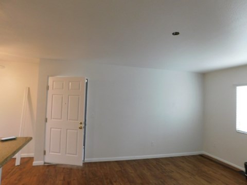 an empty living room with a white door
