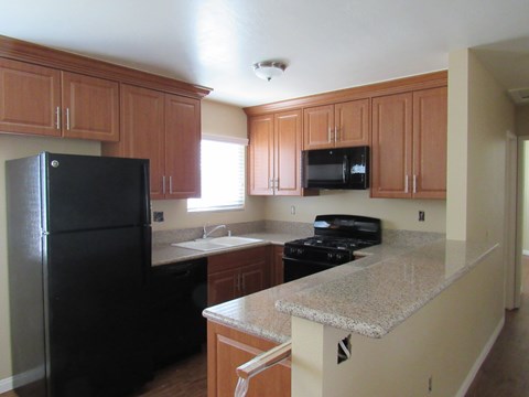 a kitchen with black appliances and granite counter tops