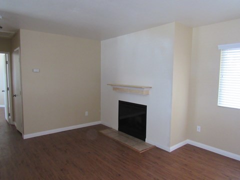 a living room with a fireplace and a wooden floor