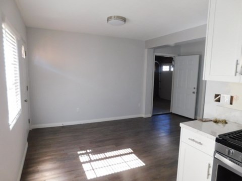 A kitchen with white cabinets and a black stove top oven.