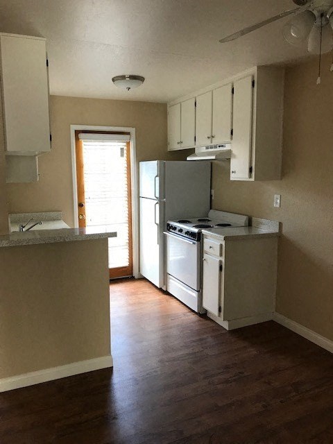 A kitchen with a refrigerator, stove, and oven.
