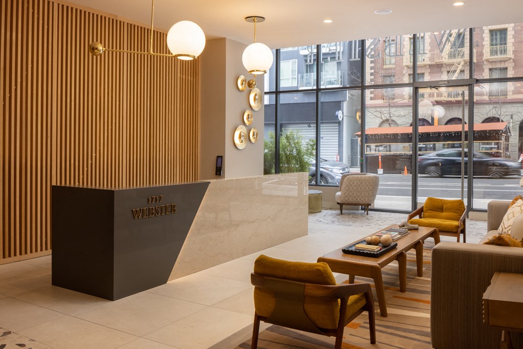 the lobby of a hotel with yellow chairs and a reception desk