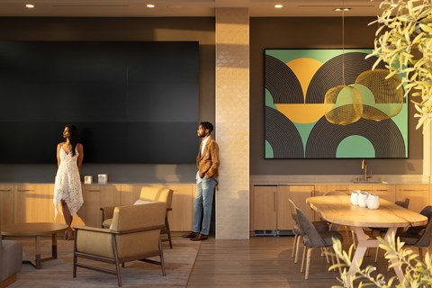a man and a woman standing in a room with tables and chairs