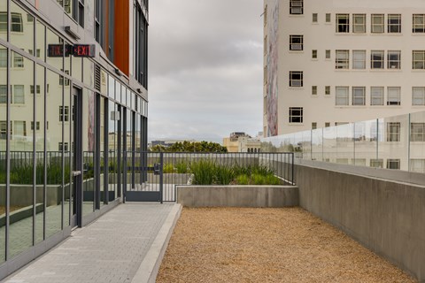 a walkway between two buildings with a view of the city